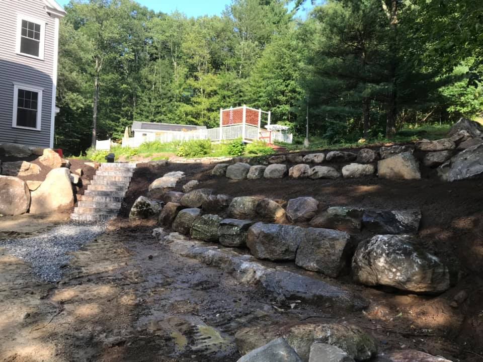 Boulder retaining walls in backyard of a clients home